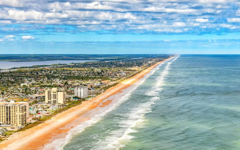 Aerial view of the Ormond Beach coastline, with condos, neighborhoods and the Halifax River beside the Atlantic Ocean.