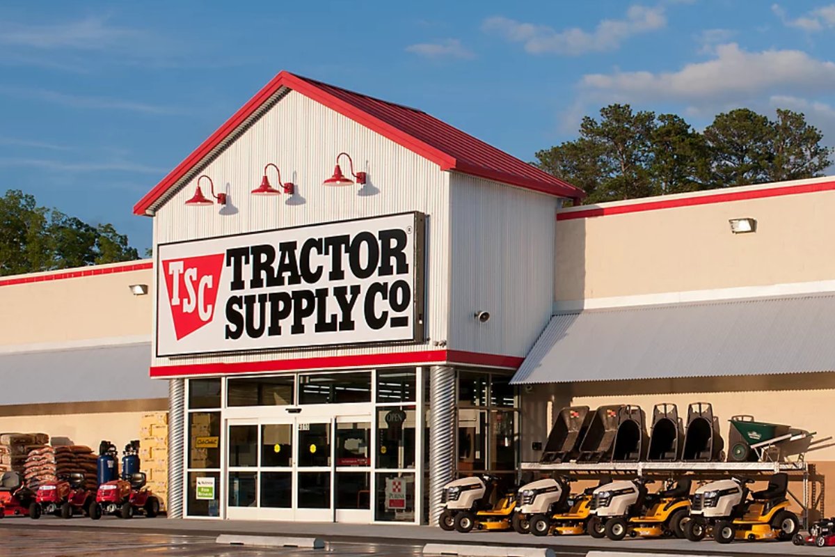 A Tractor Supply Co. storefront with mowers and outdoor equipment on display.
